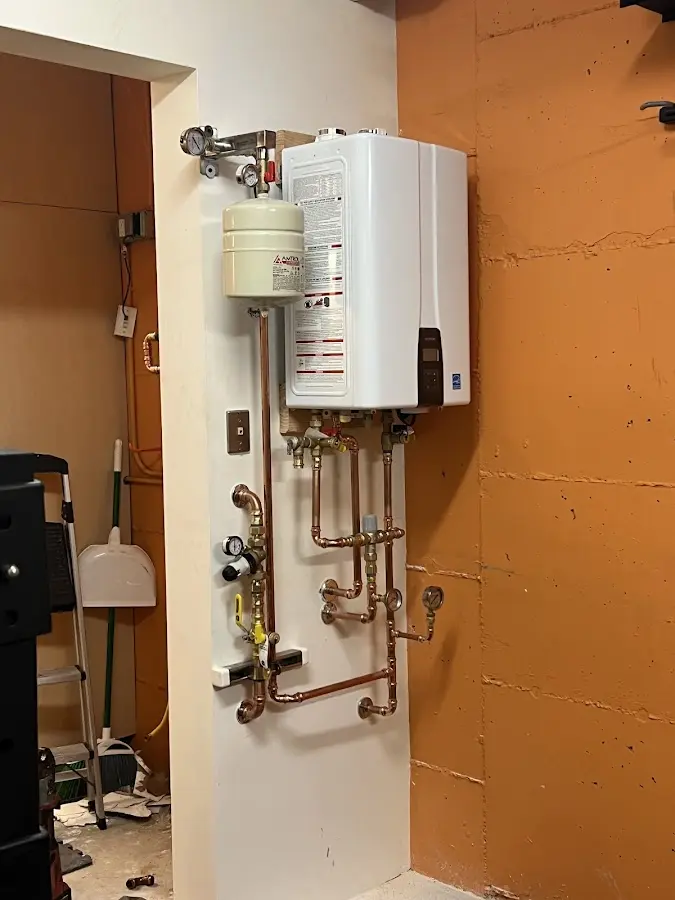 Plumbing technician inspecting water heater connections in Orlovista